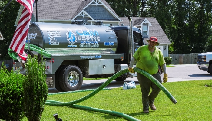 Professional septic tank pumping service with truck and hose connection